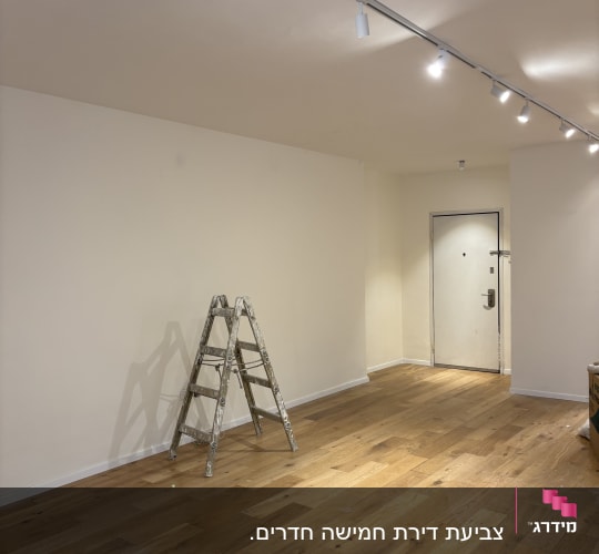 סולם בחדר עם קירות צבועים ורצפת עץ